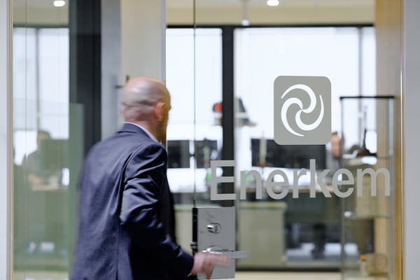 Man passing through a glass door with the Enerkem logo on it