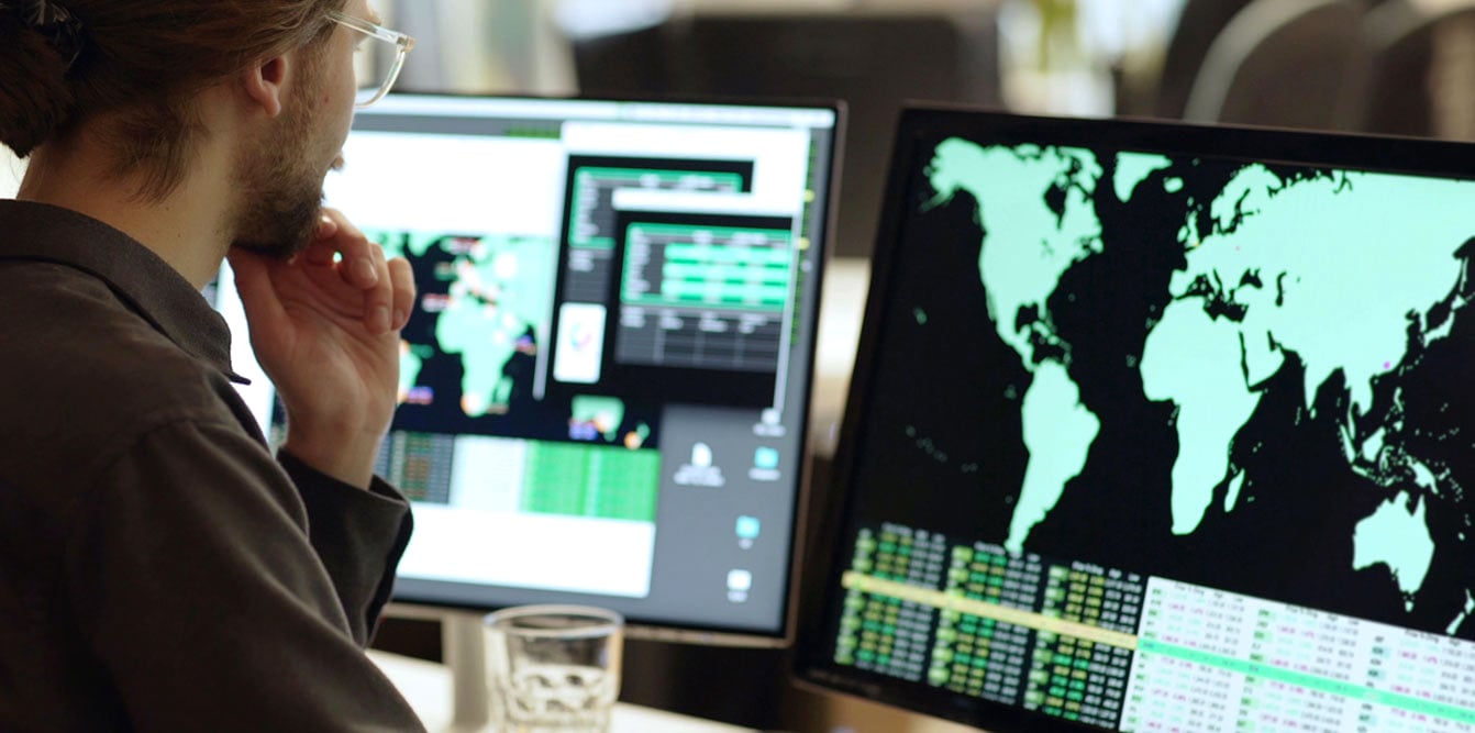 Man at his computer looking at map and data