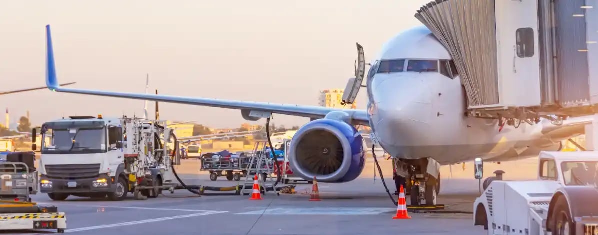 Airliner parked at airport with kerosene tanker. Handling and preparation for departure. Aircraft ground maintenance, pre-flight service.