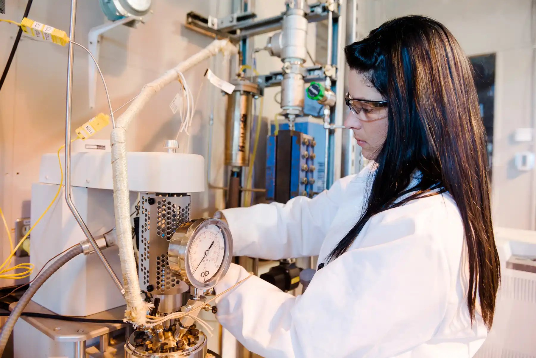 a person in a white coat working on a machine