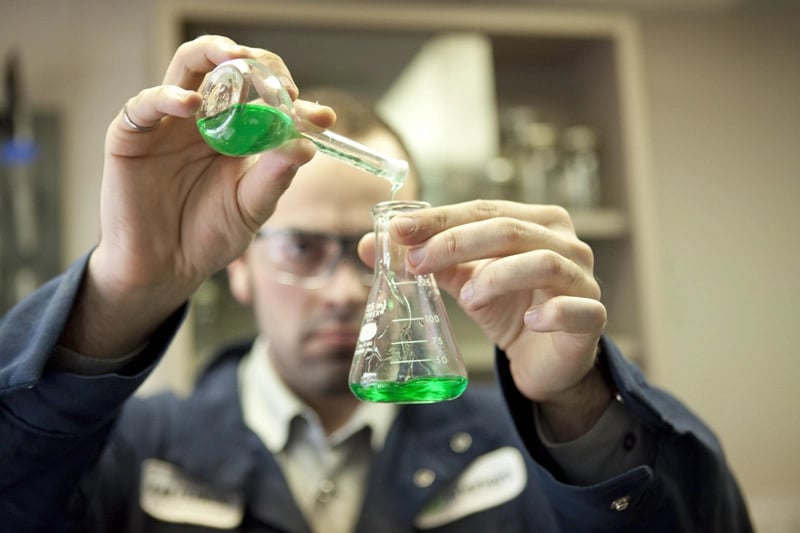 une personne versant un liquide vert dans un bécher