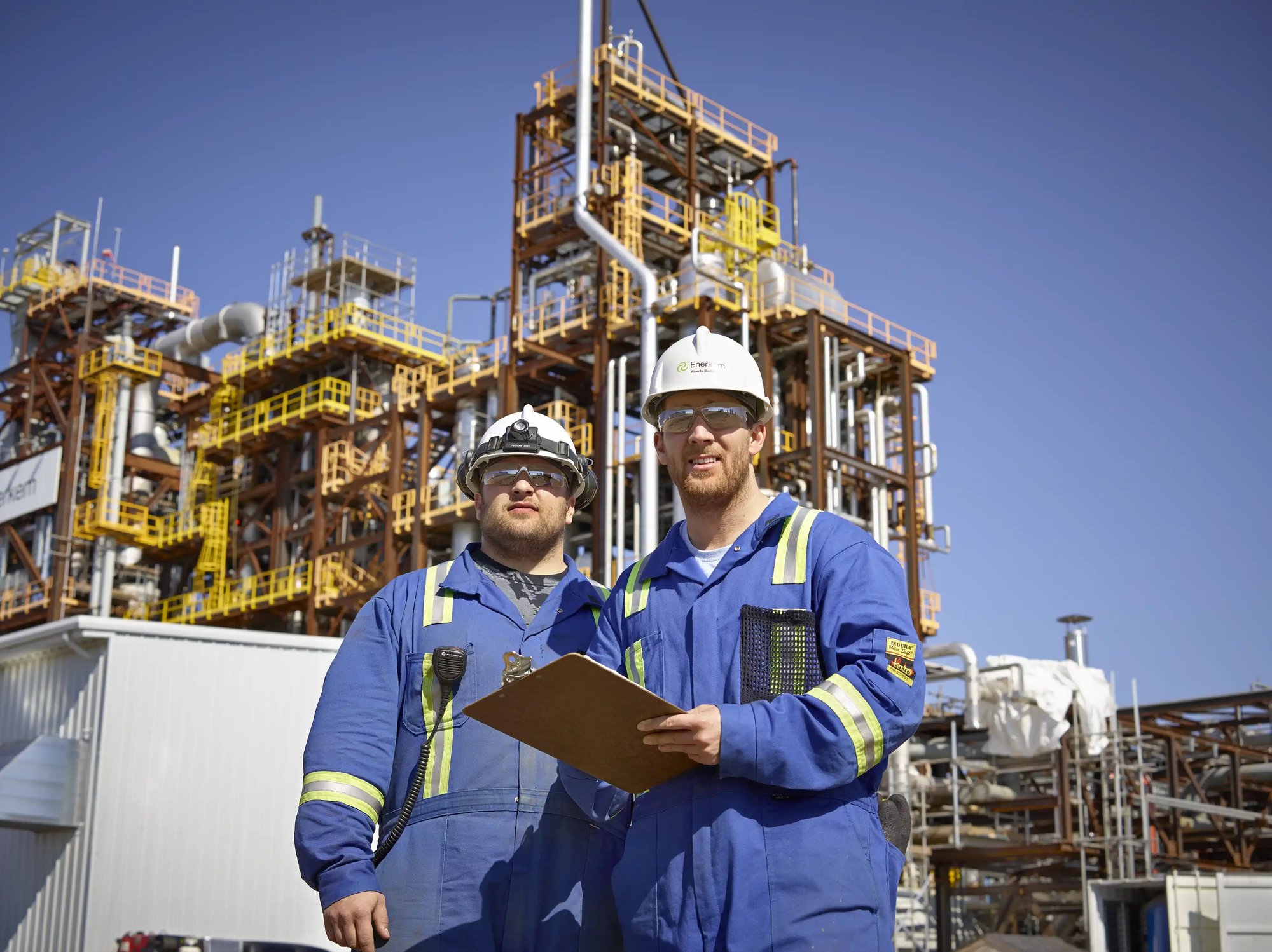 two workers wearing helmets and overalls