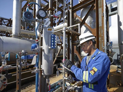 a person in a blue jumpsuit working on a machine