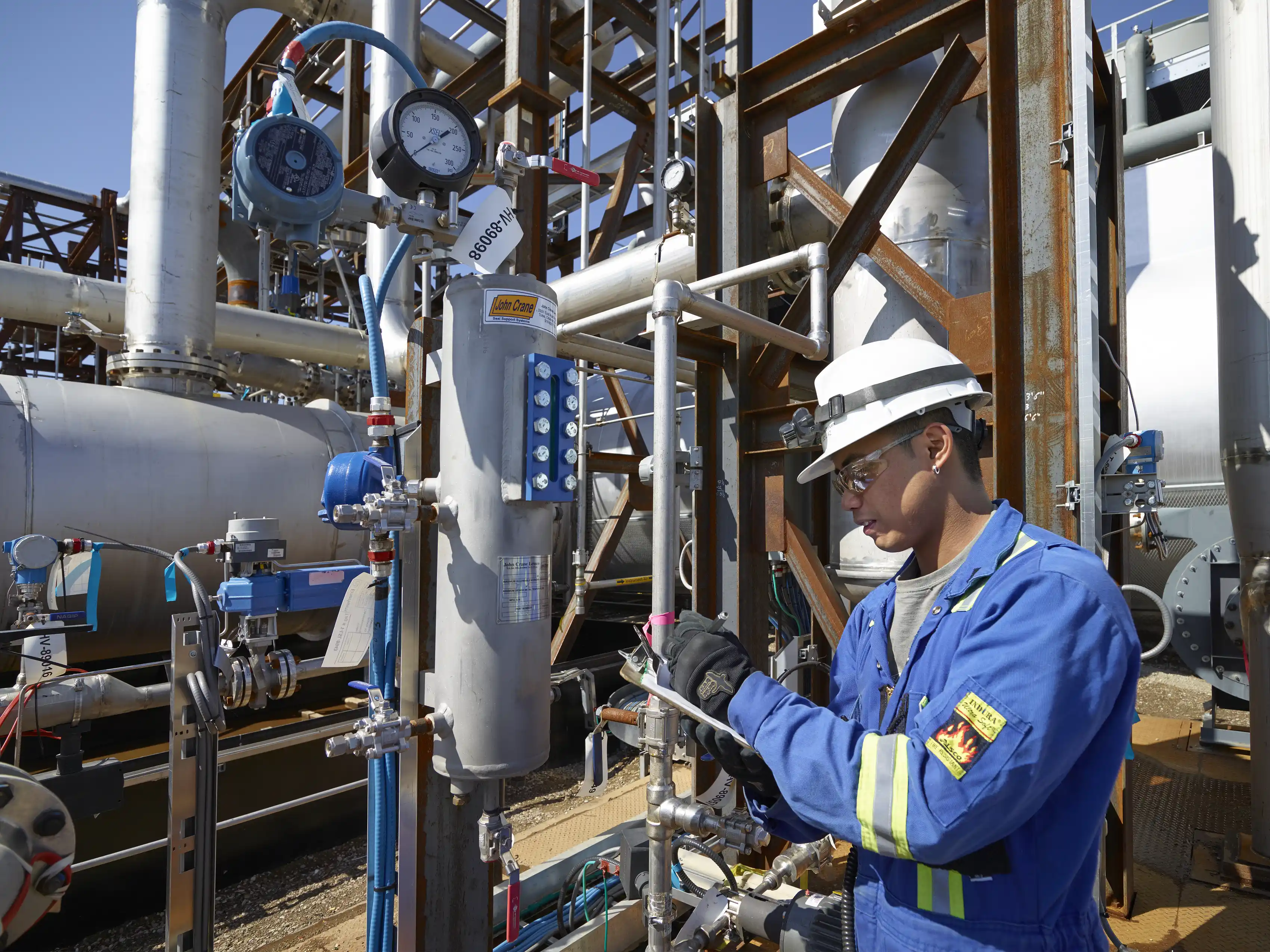 a person in a blue jumpsuit working on a machine